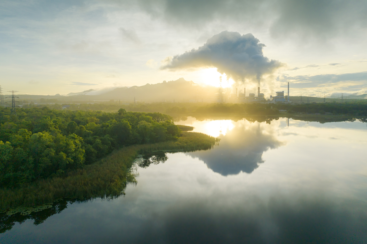 a body of water with trees and a factory in the background - Carbon Capture, Sequestration, and Utilization Law