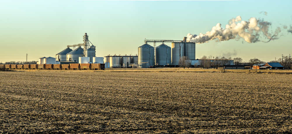 a large field with silos and smoke coming out of it - solar energy